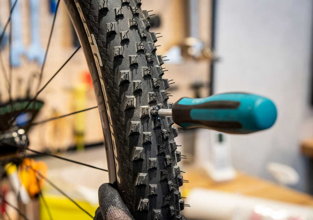 スタンズのダートツールを試すためプラスドライバーで大きめの穴をタイヤにあけている様子