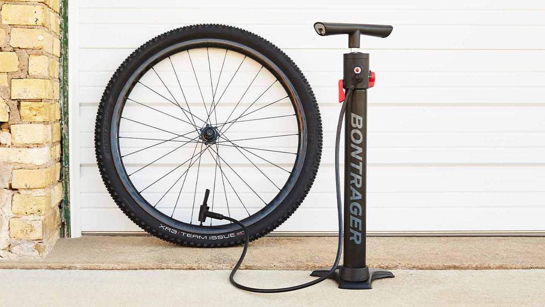 チューブレス用のフロアポンプでマウンテンバイクタイヤに空気を入れている様子