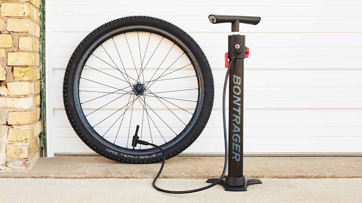 チューブレス用のフロアポンプでマウンテンバイクタイヤに空気を入れている様子