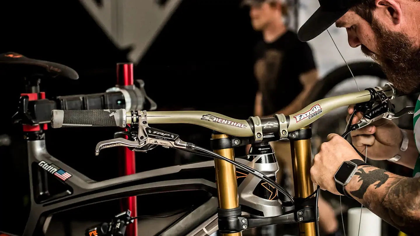 レンサルステムとハンドルを装備したDHバイクのメンテナンスをするメカニック