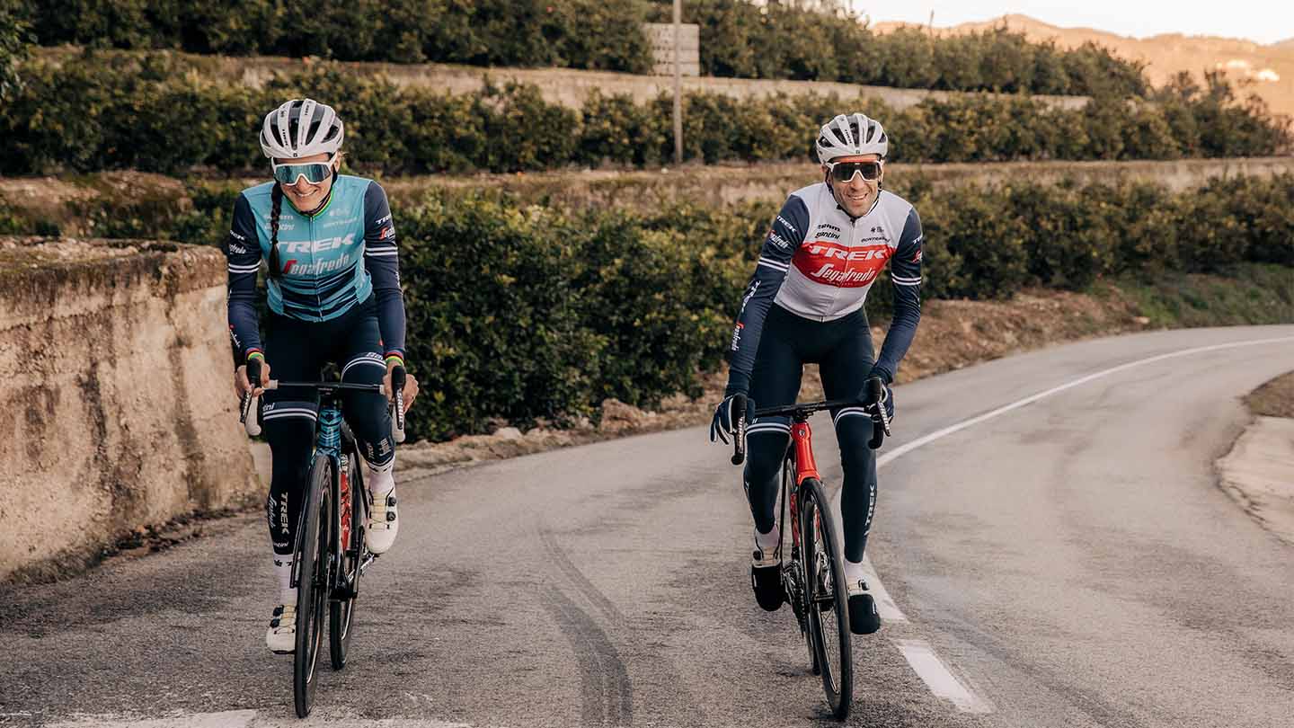 ダンシングで坂道を上る男女のロードレーサー