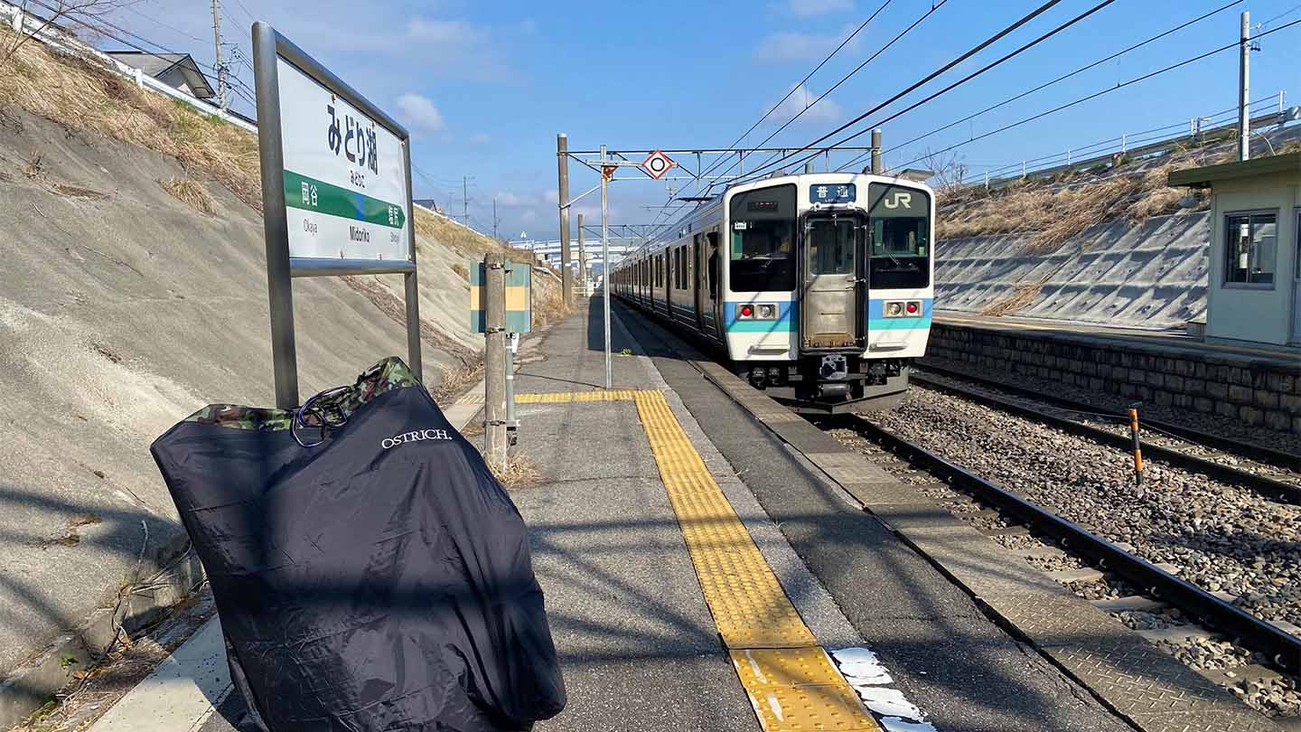 みどり湖駅のホームで輪行袋と到着する電車を一緒に撮影