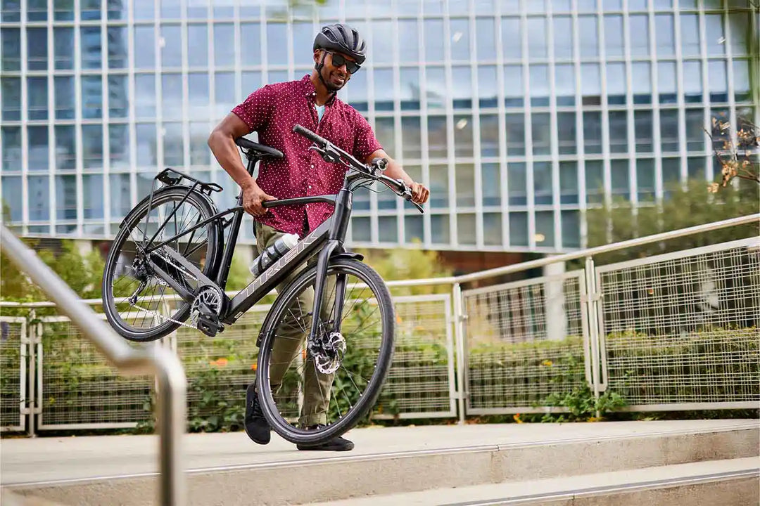 FX+ 2 eクロスバイクを持ち上げている男性