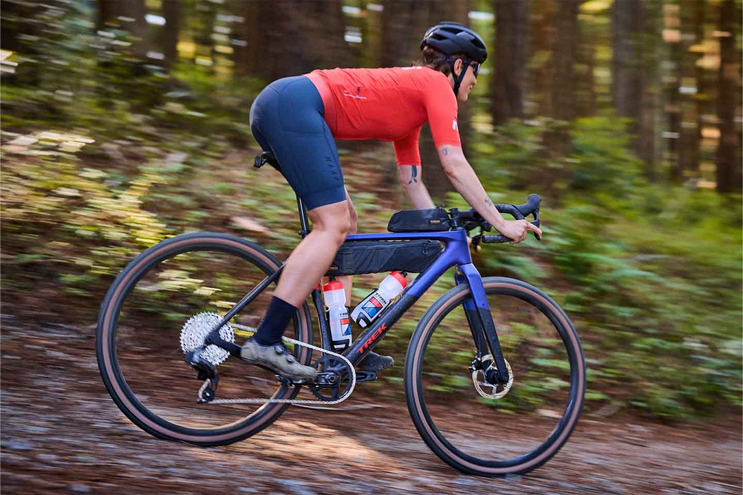 林間のグラベルロードを下るライダー