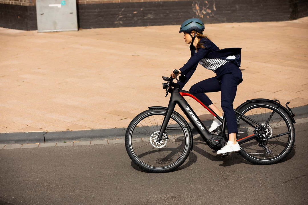 オフィスカジュアルな服装でeバイクで通勤するイメージ写真