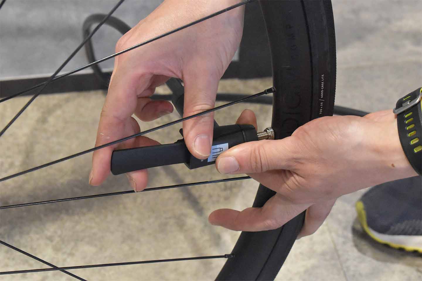 フロアポンプのレバーを固定し、空気圧メーターを見ながらポンピングしている様子