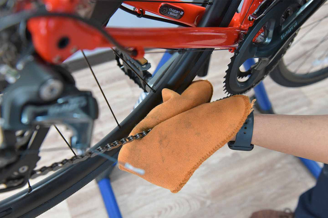 チェーンクリーナーで溶け出た汚れをふき取る作業風景