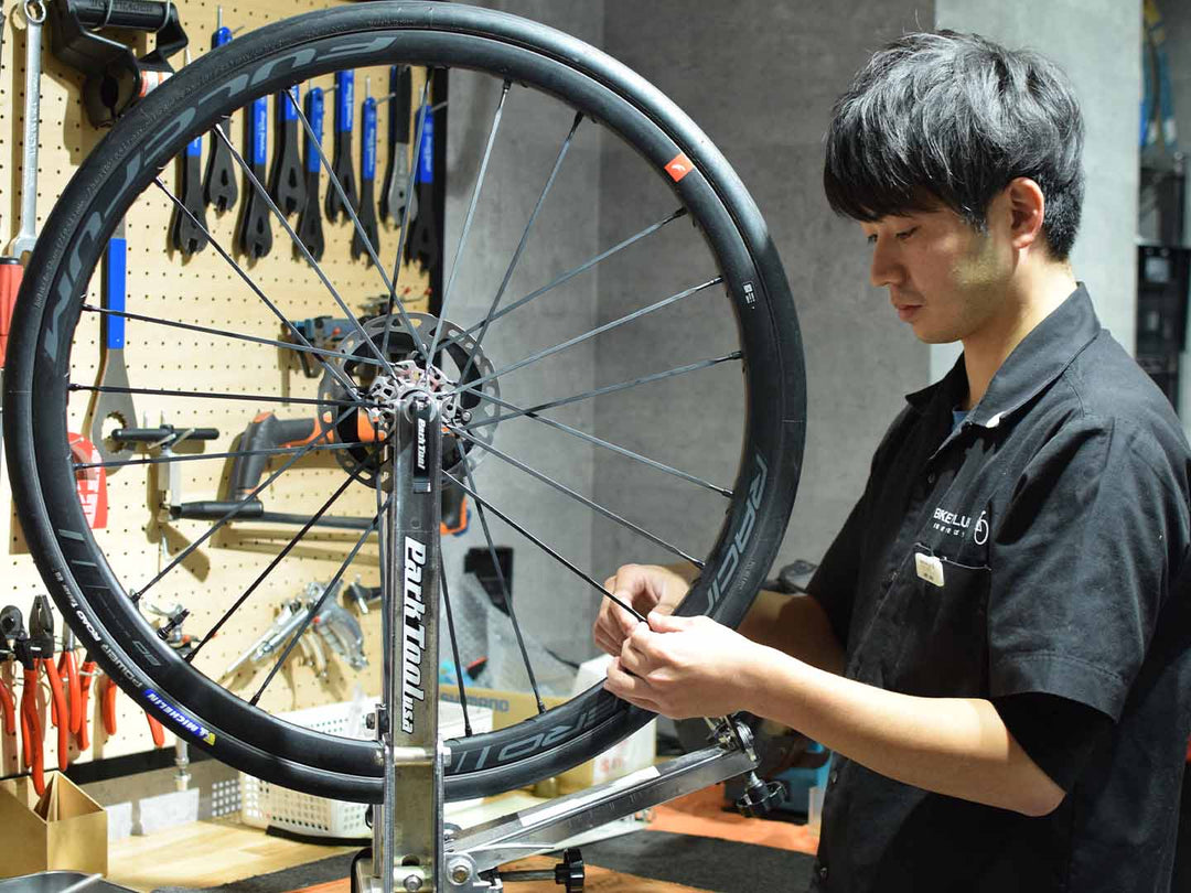 ロードホイールを振れ取り台に乗せ振れ取りをする様子