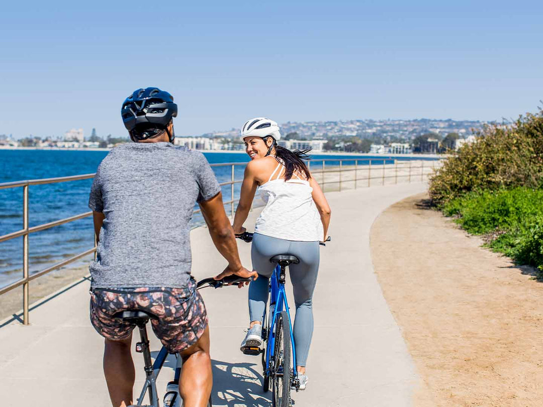 クロスバイクを乗りながら笑顔で振り向く女性の写真