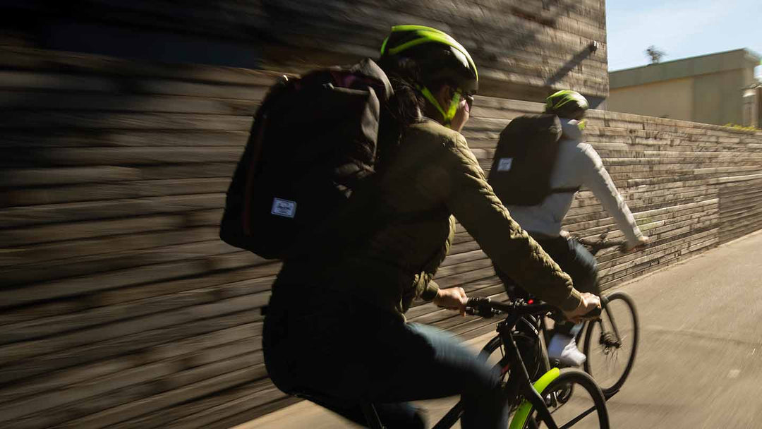 バックパックを背負ってクロスバイクに乗っている様子