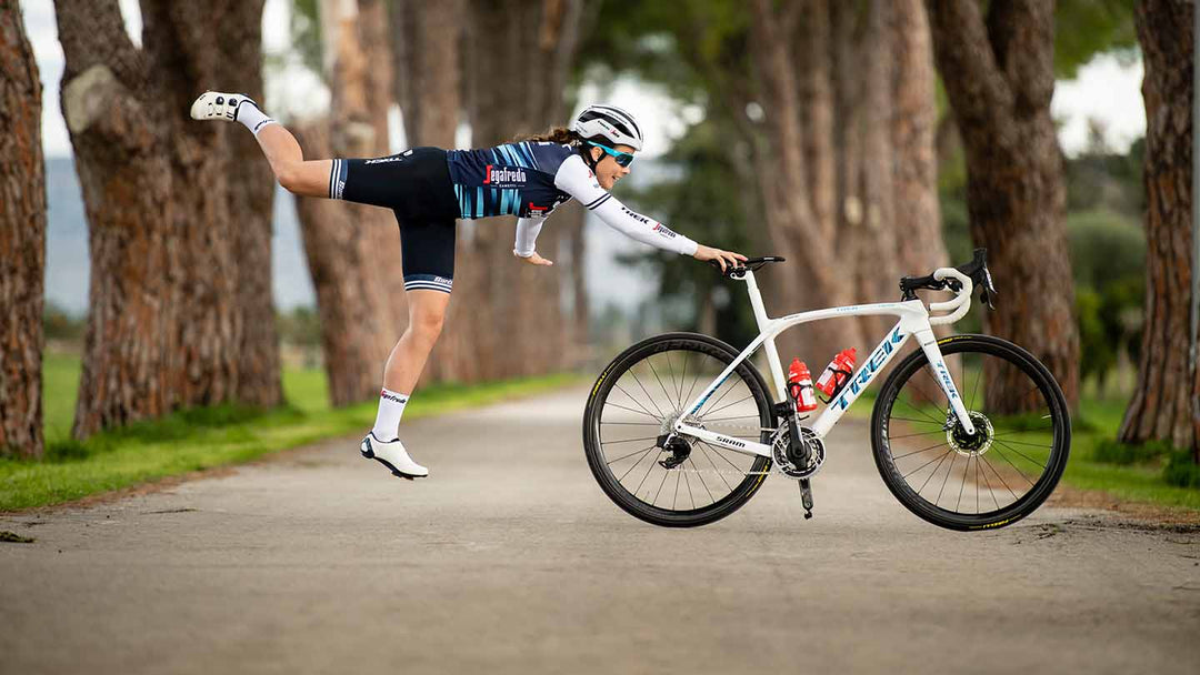 ロードバイクのサドルに手を付いている人が自転車の後方で宙に浮いているかのような写真