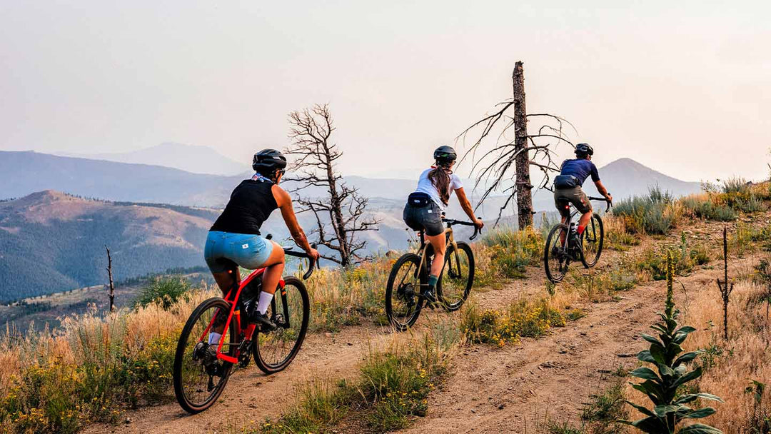 荒れたジープロードを走る３人のグラベルサイクリストの写真