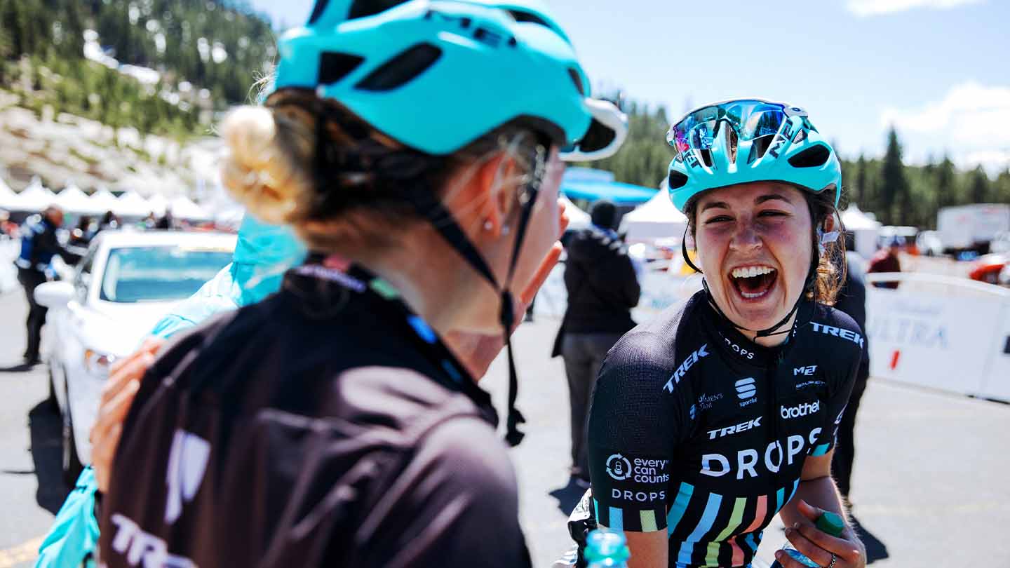 レース結果の喜びを満面の笑顔で分かち合う女性プロロードレーサーの写真