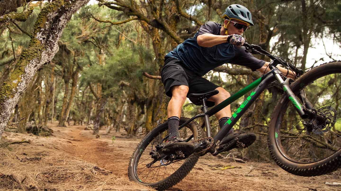 マニュアルをしてトレイルを走り抜けるマウンテンバイカーの写真