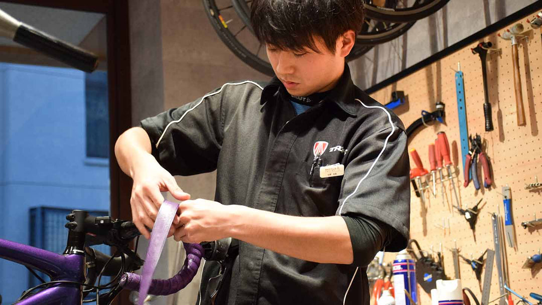 ロードバイクのバーテープ交換をしているメカニックスタッフの写真