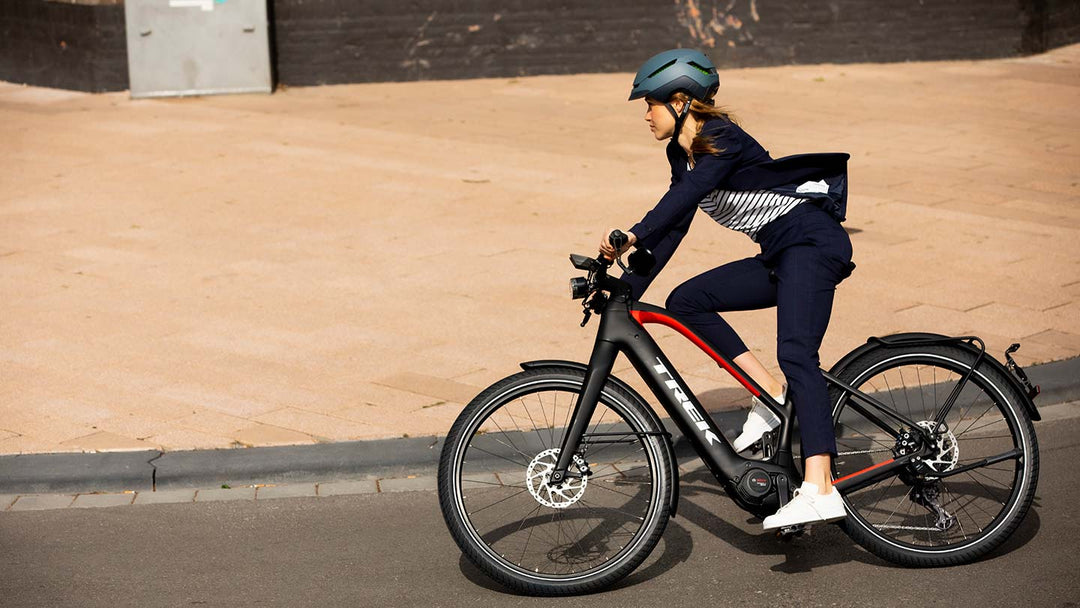 オフィスカジュアルな服装でeバイクで通勤するイメージ写真