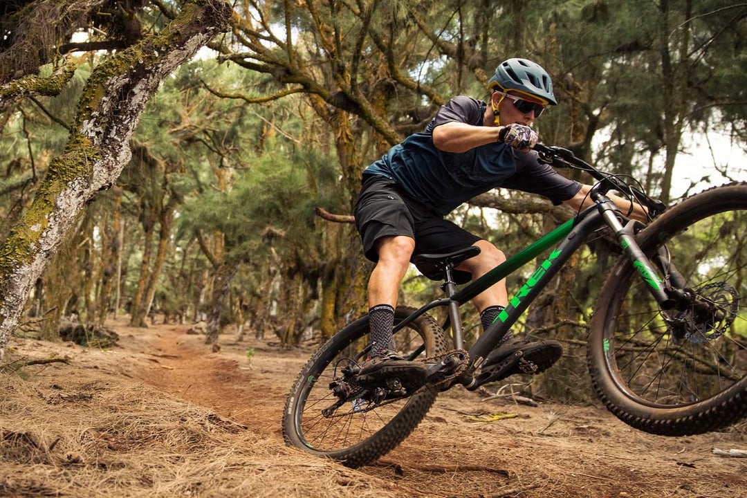 マニュアルをしながらトレイルを走るマウンテンバイカーの写真