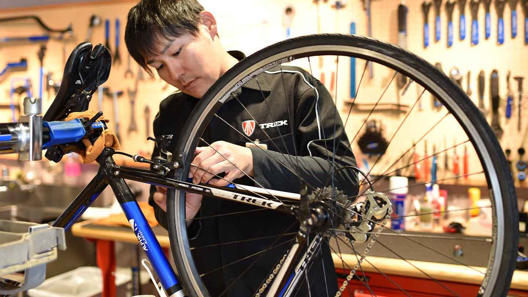 メカニックがブレーキ調整をしている写真