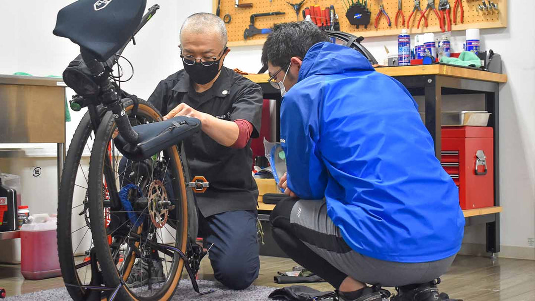 輪行袋にロードバイクを収納するための方法を説明している様子