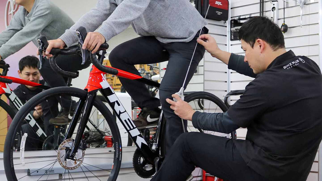 ペダリング中の膝関節の角度をチェックしながら適正なサドル高にフィッティングをしている様子