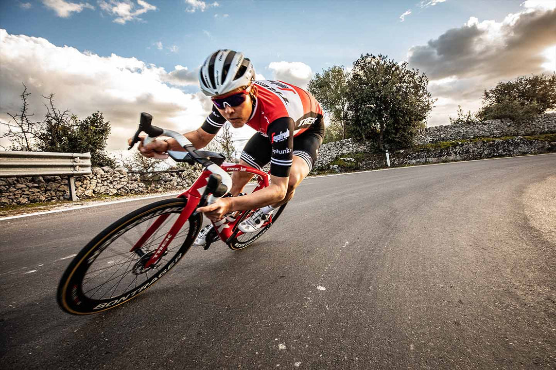 下ハンドルを握り重心を低くしてハイスピードで下るロードバイクのイメージ写真