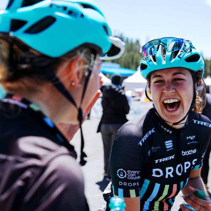 レース結果の喜びを満面の笑顔で分かち合う女性プロロードレーサーの写真