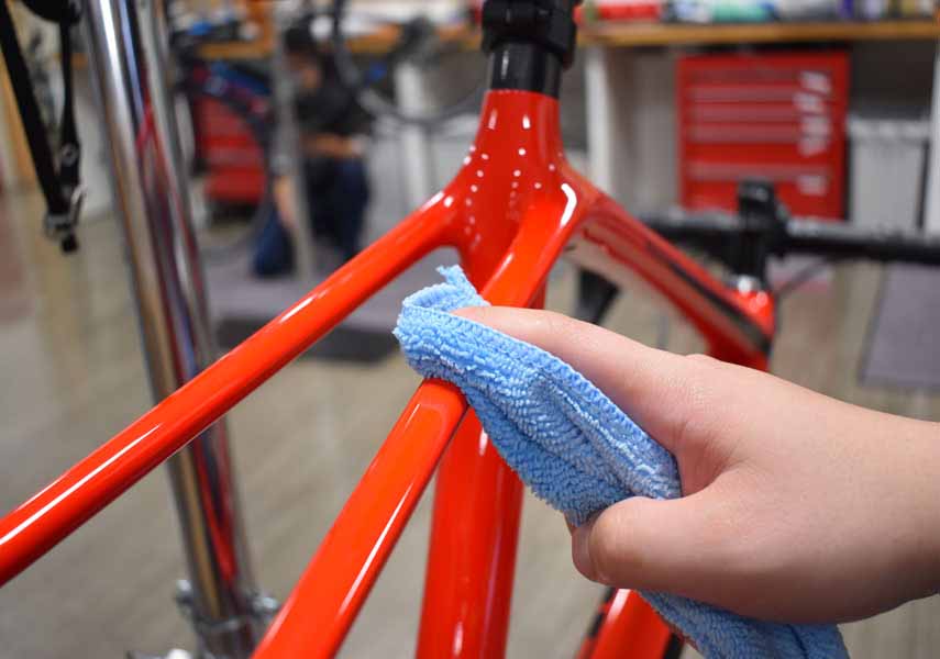 もう一枚のマイクロファイバータオルでフレームを拭き上げている様子