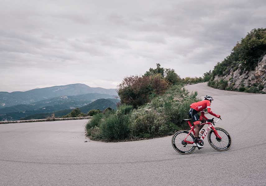 ヘアピンカーブの上りを果敢に攻めるロードバイクの写真