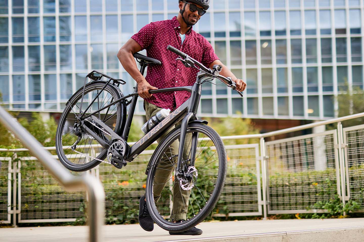 トレック FX+2 電動アシストクロスバイクを軽く持ち上げている様子