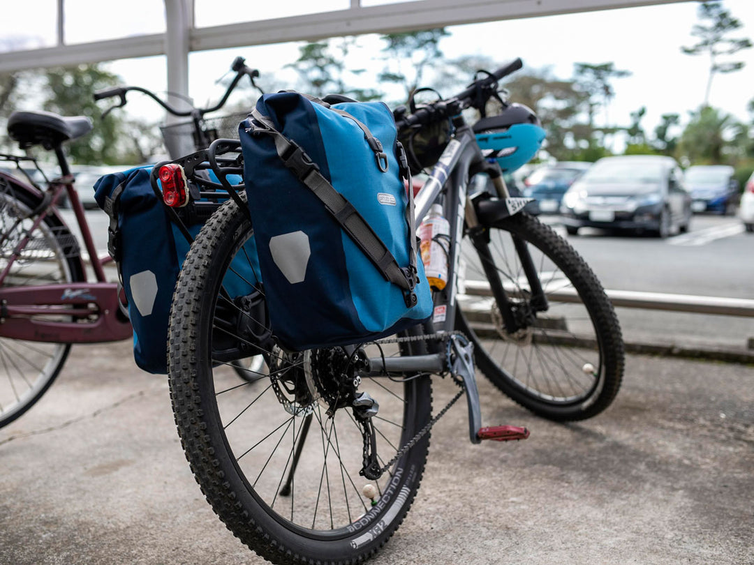 リアキャリアにオルトリーブのパニアバッグをつけたマウテンバイクをななめ後ろから撮影した様子