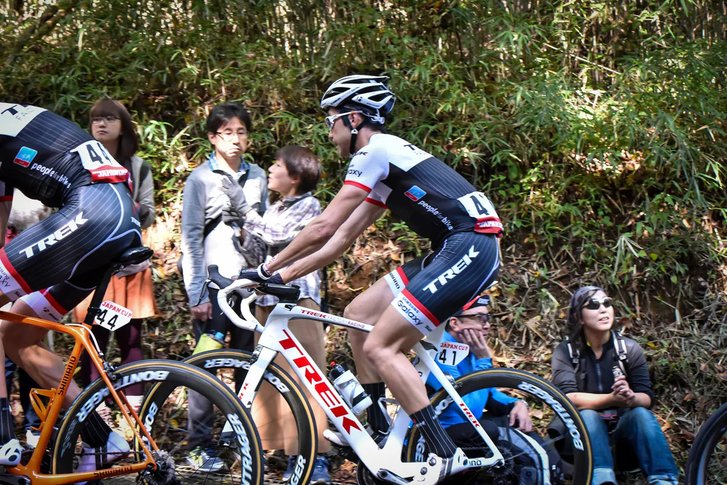 ヒルクライム中に上ハンドルを握り、呼吸を楽にして登るライダー