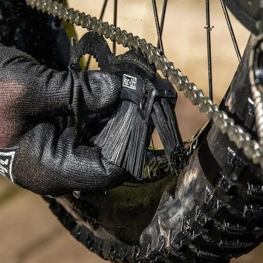 マックオフのクロウブラシを使用してチェーン内側の汚れを掻き出しているイメージ画像